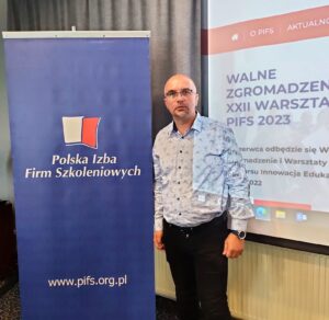 Tomasz Radkiewicz na tle baneru PIFS